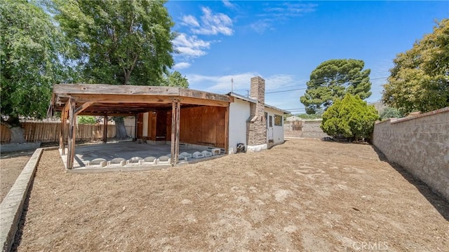 10816 Foothill Blvd, Sylmar, CA 91342 - back of property with a fenced backyard, a patio area, and a chimney