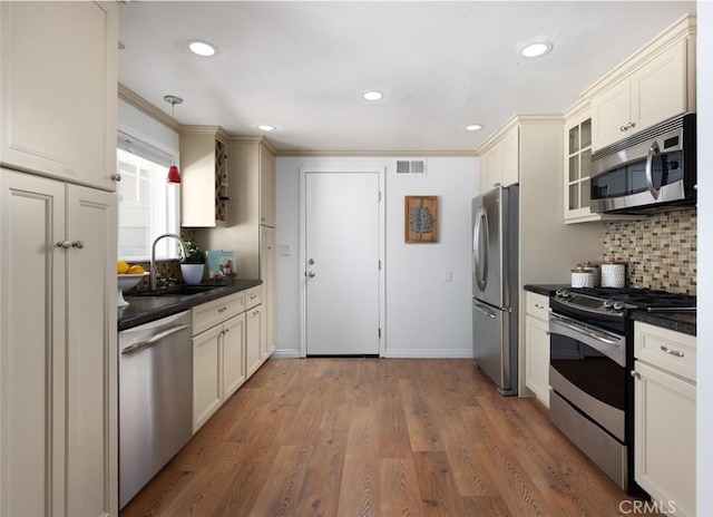 2119 E Denise Ave, Orange, CA 92867 - kitchen with appliances with stainless steel finishes, dark countertops, decorative backsplash, glass insert cabinets, and recessed lighting