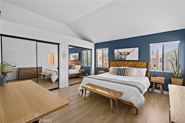 990 La Paz Rd Unit 49, Placentia, CA 92870 - bedroom featuring multiple closets, lofted ceiling, multiple windows, and light wood-style floors