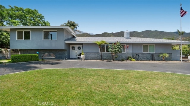 8356 Bella Vista Dr, Rancho Cucamonga, CA 91701 - split level home with stucco siding, a front yard, a mountain view, stone siding, and a chimney