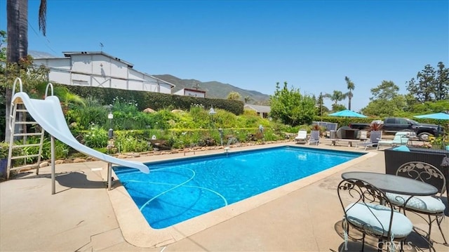 8356 Bella Vista Dr, Rancho Cucamonga, CA 91701 - outdoor pool with a water slide, a patio area, and a mountain view