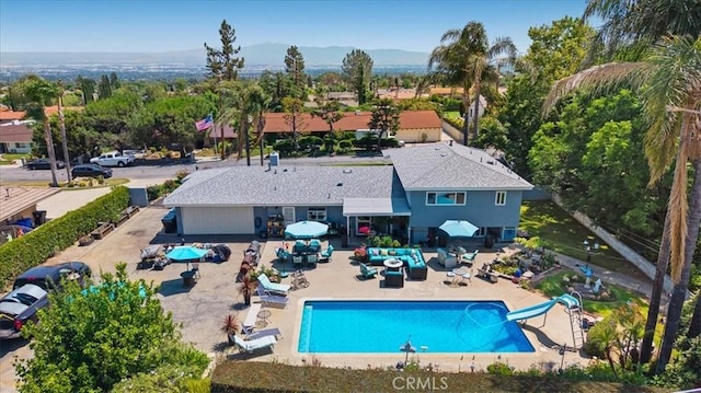 8356 Bella Vista Dr, Rancho Cucamonga, CA 91701 - view of pool with a water slide, a patio, an outdoor hangout area, and a mountain view