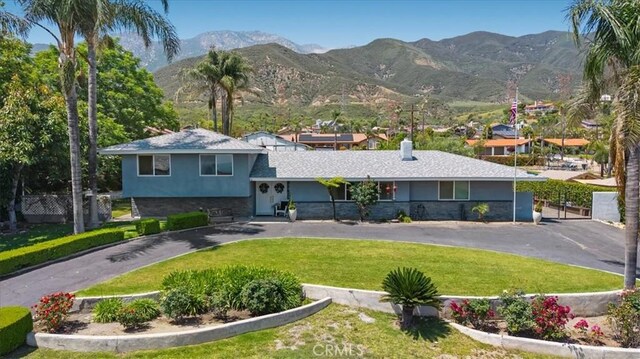8356 Bella Vista Dr, Rancho Cucamonga, CA 91701 - view of front of home featuring a mountain view, stucco siding, stone siding, and asphalt driveway