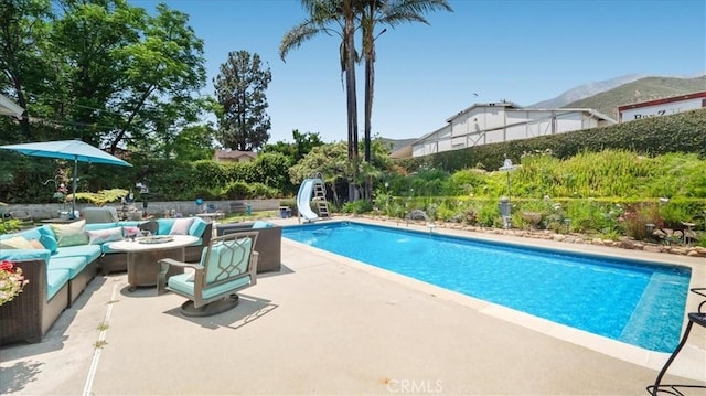 8356 Bella Vista Dr, Rancho Cucamonga, CA 91701 - view of swimming pool with a water slide, an outdoor living space with a fire pit, a patio, and a mountain view