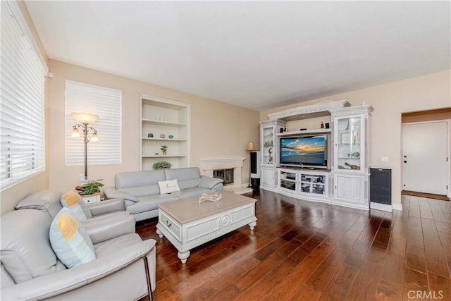 6242 E Inverness Pl, Orange, CA 92869 - living room featuring dark wood-type flooring, a fireplace with raised hearth, and built in features