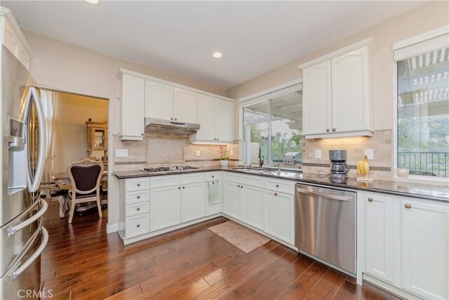 6242 E Inverness Pl, Orange, CA 92869 - kitchen featuring appliances with stainless steel finishes, dark countertops, under cabinet range hood, recessed lighting, and white cabinets