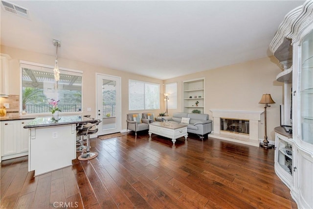 6242 E Inverness Pl, Orange, CA 92869 - living room featuring dark wood finished floors, a glass covered fireplace, and built in features