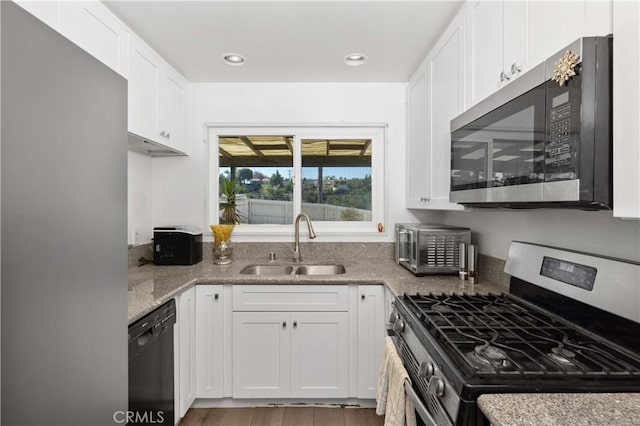 4657 Chateau Pl, San Diego, CA 92117 - kitchen featuring appliances with stainless steel finishes, white cabinetry, light stone countertops, recessed lighting, and wood finished floors