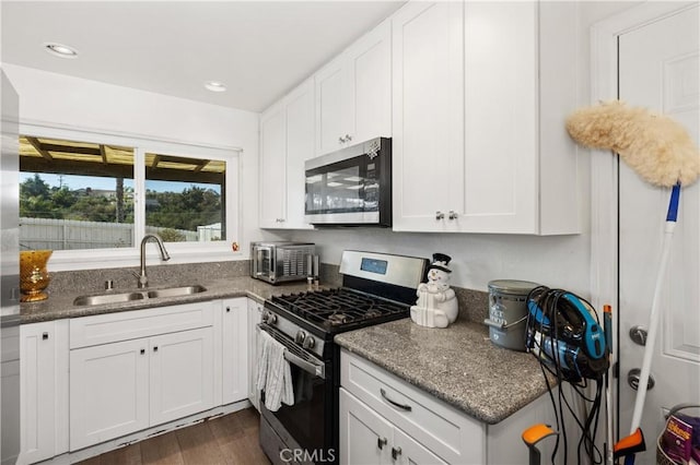 4657 Chateau Pl, San Diego, CA 92117 - kitchen featuring appliances with stainless steel finishes, white cabinetry, dark wood-style flooring, recessed lighting, and dark stone counters