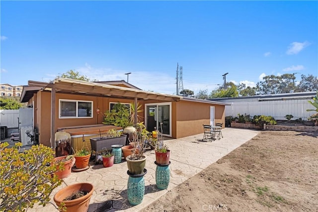 4657 Chateau Pl, San Diego, CA 92117 - back of house featuring a patio, stucco siding, a fenced backyard, and a hot tub