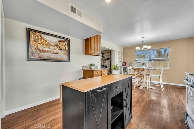 21304 Carriage Dr, Tehachapi, CA 93561 - kitchen featuring a chandelier, light countertops, hardwood / wood-style floors, brown cabinets, and hanging light fixtures