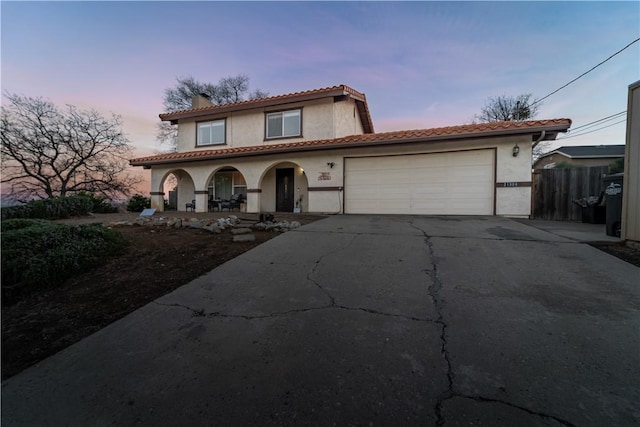 21304 Carriage Dr, Tehachapi, CA 93561 - mediterranean / spanish home featuring a porch, stucco siding, asphalt driveway, and a garage