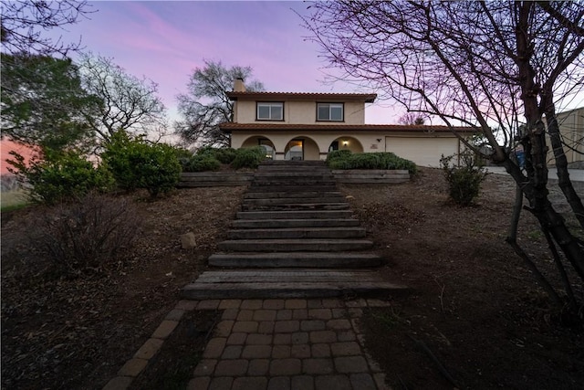21304 Carriage Dr, Tehachapi, CA 93561 - mediterranean / spanish home with stairway, stucco siding, a chimney, and an attached garage
