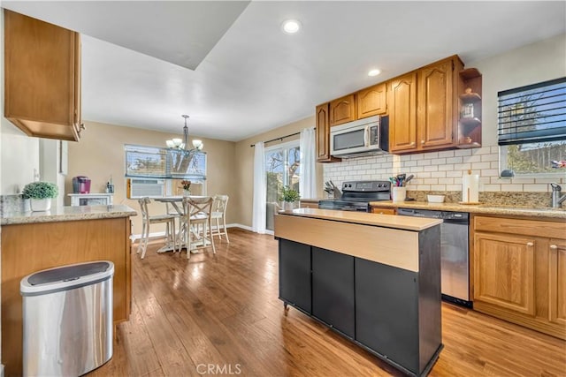 21304 Carriage Dr, Tehachapi, CA 93561 - kitchen featuring appliances with stainless steel finishes, light wood finished floors, backsplash, and recessed lighting