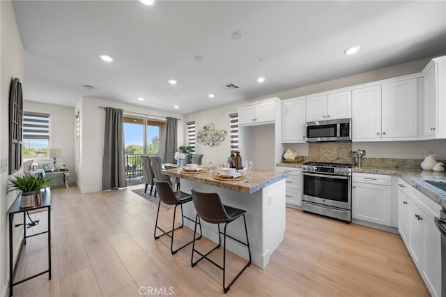 18309 Goldbark Way, Yorba Linda, CA 92886 - kitchen with stainless steel appliances, healthy amount of natural light, white cabinetry, light wood-style flooring, and recessed lighting