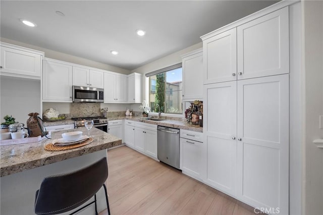 18309 Goldbark Way, Yorba Linda, CA 92886 - kitchen featuring stainless steel appliances, white cabinets, light wood-style flooring, recessed lighting, and light stone counters