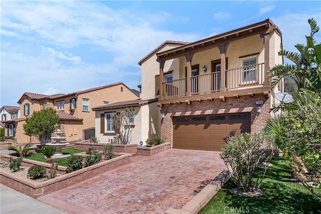 15448 Six M Ranch Ln, Fontana, CA 92336 - view of front facade with a balcony, stucco siding, a garage, decorative driveway, and brick siding