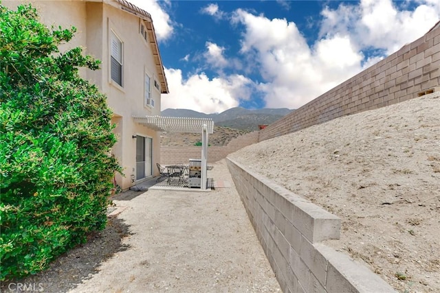 5575 Osborne Ct, San Bernardino, CA 92407 - fenced backyard featuring a patio area, a pergola, a mountain view, and outdoor dining space