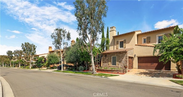 41 Balcony, Irvine, CA 92603 - view of front facade with stone siding, a tiled roof, driveway, an attached garage, and a chimney