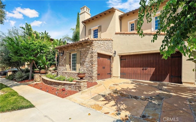 41 Balcony, Irvine, CA 92603 - mediterranean / spanish-style house with a garage, stone siding, stucco siding, a tile roof, and a chimney