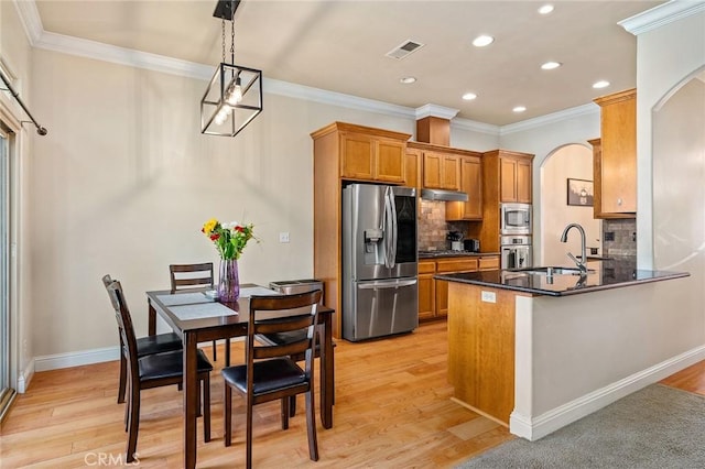 1968 Bancroft Dr, Chico, CA 95928 - kitchen with appliances with stainless steel finishes, arched walkways, recessed lighting, dark countertops, and brown cabinets