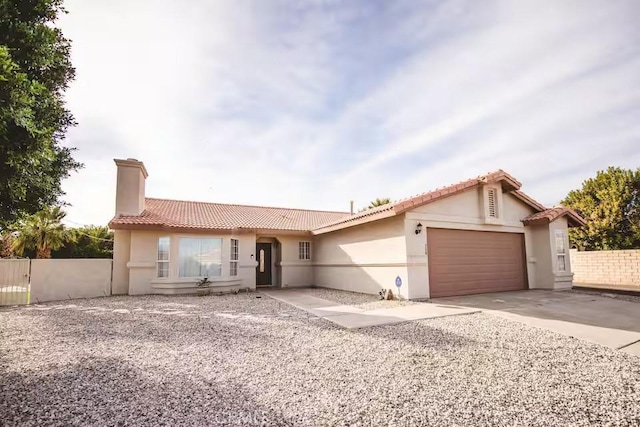 30319 Desert Moon Dr, Thousand Palms, CA 92276 - view of front of property with a tile roof, an attached garage, stucco siding, and a chimney