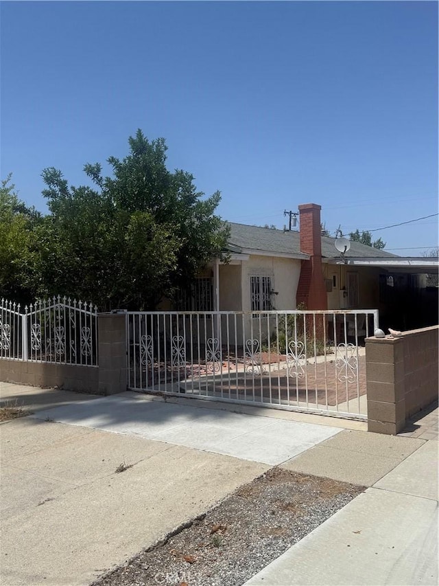119 W Francis St, Corona, CA 92882 - view of front of property with a gate, stucco siding, and a chimney