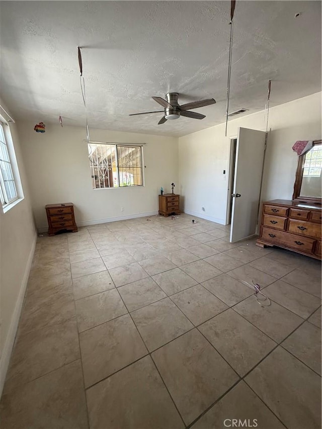 119 W Francis St, Corona, CA 92882 - unfurnished living room with healthy amount of natural light, a textured ceiling, ceiling fan, and tile patterned floors