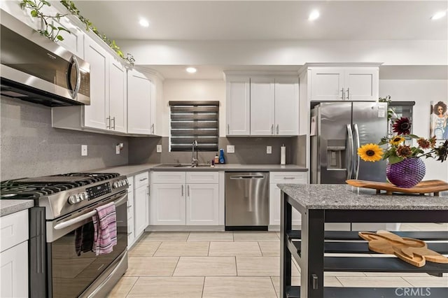 4842 Buchanan St, Los Angeles, CA 90042 - kitchen featuring stainless steel appliances, decorative backsplash, white cabinets, and recessed lighting