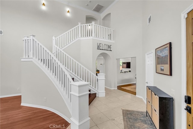 1775 Honors Ln, Corona, CA 92883 - stairway with arched walkways, tile patterned flooring, a high ceiling, and crown molding
