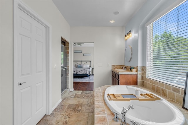1775 Honors Ln, Corona, CA 92883 - ensuite bathroom with vanity, plenty of natural light, a garden tub, and stone finish flooring