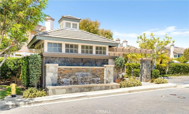 100 Stoney, Laguna Niguel, CA 92677 - view of front of property featuring stone siding, a tiled roof, and a chimney