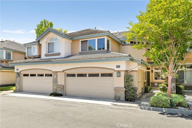100 Stoney, Laguna Niguel, CA 92677 - view of property with stone siding, stucco siding, an attached garage, and a tiled roof