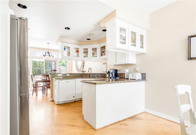 100 Stoney, Laguna Niguel, CA 92677 - kitchen with a peninsula, dishwasher, freestanding refrigerator, light wood-style floors, and white cabinets
