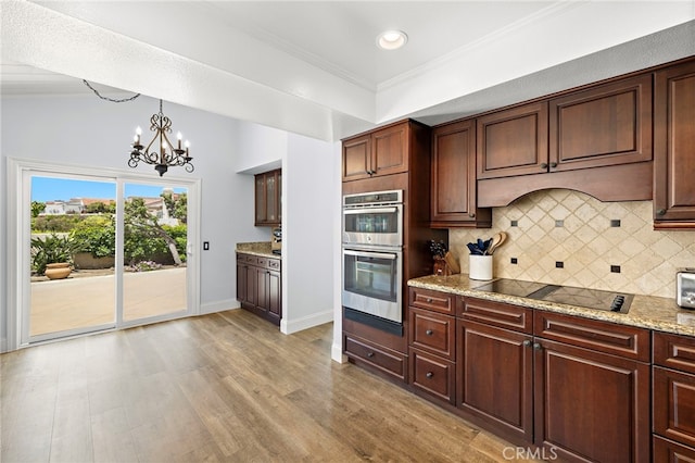 24191 Vis D Oro, Dana Point, CA 92629 - kitchen with double oven, black electric stovetop, a chandelier, tasteful backsplash, and light wood-type flooring