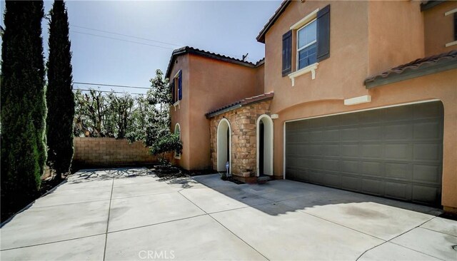 1855 W Willow Ave, Anaheim, CA 92804 - view of front of house with a tiled roof, stone siding, stucco siding, an attached garage, and driveway