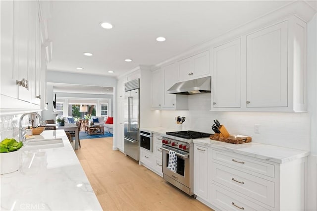 113 Via Yella, Newport Beach, CA 92663 - kitchen with high end appliances, under cabinet range hood, white cabinetry, light wood finished floors, and recessed lighting
