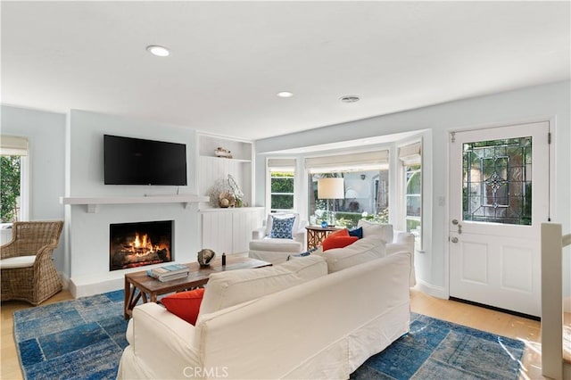 113 Via Yella, Newport Beach, CA 92663 - living room with healthy amount of natural light, a warm lit fireplace, wood finished floors, and recessed lighting