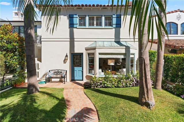 113 Via Yella, Newport Beach, CA 92663 - back of property featuring stucco siding, a lawn, and a standing seam roof
