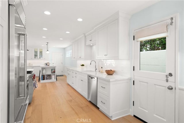 113 Via Yella, Newport Beach, CA 92663 - kitchen featuring high quality appliances, white cabinets, light wood-style flooring, healthy amount of natural light, and recessed lighting