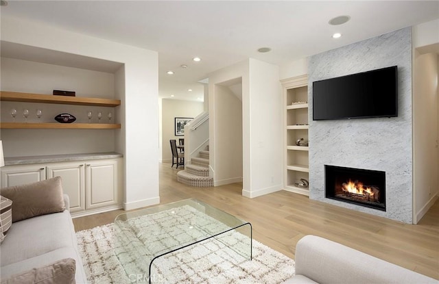 2534 Bungalow Pl Unit 87, Corona Del Mar, CA 92625 - living area with light wood-type flooring, a large fireplace, built in shelves, stairway, and recessed lighting