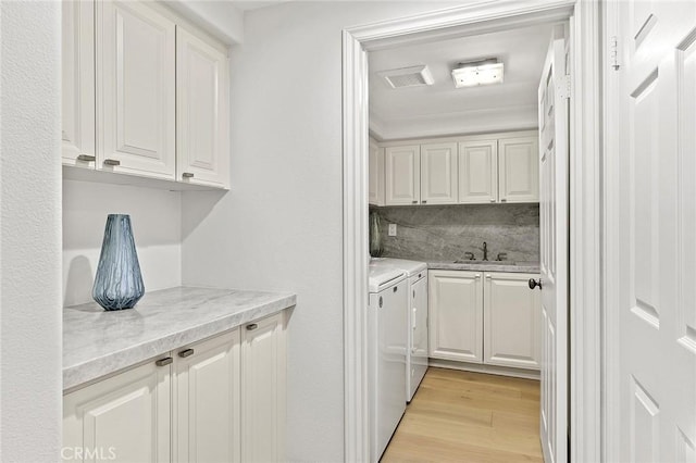 2534 Bungalow Pl Unit 87, Corona Del Mar, CA 92625 - washroom featuring cabinet space, washer and clothes dryer, and light wood-type flooring