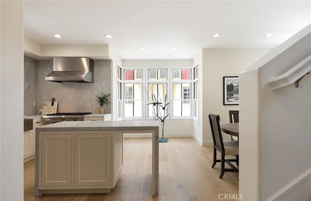 2534 Bungalow Pl Unit 87, Corona Del Mar, CA 92625 - kitchen with wall chimney range hood, light wood-style flooring, recessed lighting, light stone countertops, and stainless steel gas stovetop