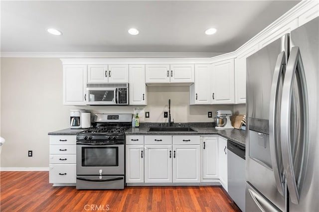 43249 42nd St W, Lancaster, CA 93536 - kitchen with stainless steel appliances, white cabinets, dark wood finished floors, recessed lighting, and ornamental molding