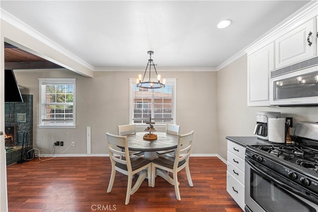 43249 42nd St W, Lancaster, CA 93536 - dining space with dark wood-style floors, a fireplace, ornamental molding, a chandelier, and recessed lighting