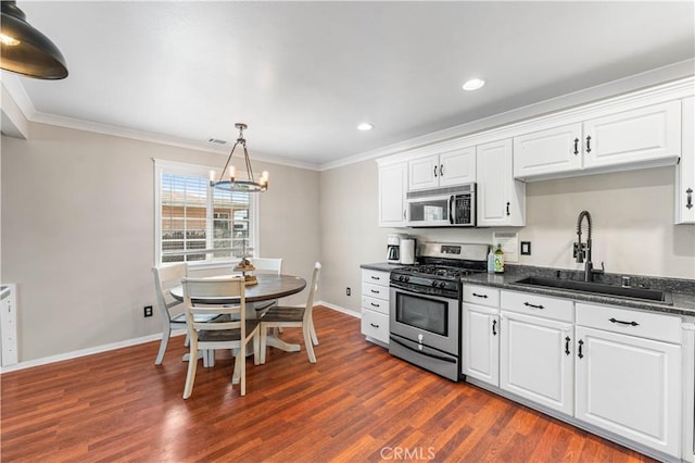 43249 42nd St W, Lancaster, CA 93536 - kitchen with stainless steel range with gas cooktop, ornamental molding, dark wood-style floors, white cabinets, and a chandelier