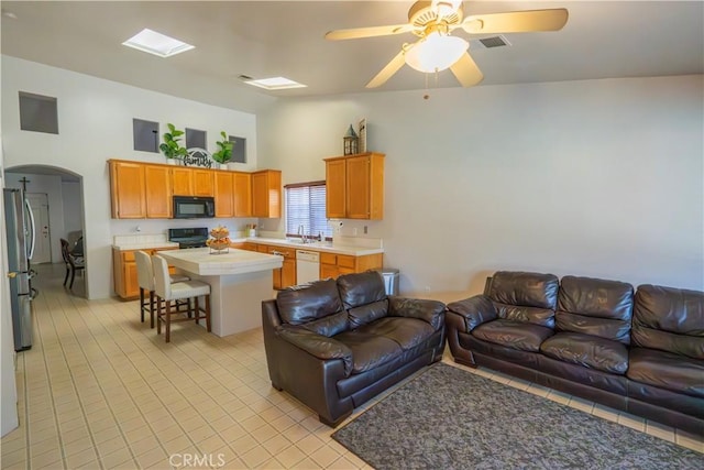 10606 Anacostia Way, Bakersfield, CA 93311 - living room with light tile patterned floors, arched walkways, a high ceiling, and ceiling fan