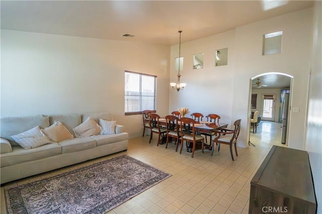 10606 Anacostia Way, Bakersfield, CA 93311 - living room with arched walkways, a ceiling fan, a chandelier, a high ceiling, and light tile patterned floors
