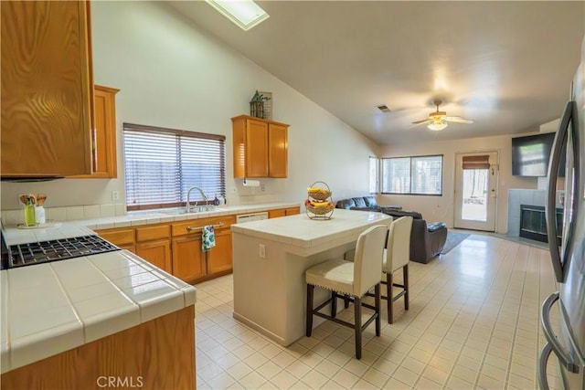 10606 Anacostia Way, Bakersfield, CA 93311 - kitchen featuring open floor plan, tile counters, vaulted ceiling, light tile patterned flooring, and a breakfast bar
