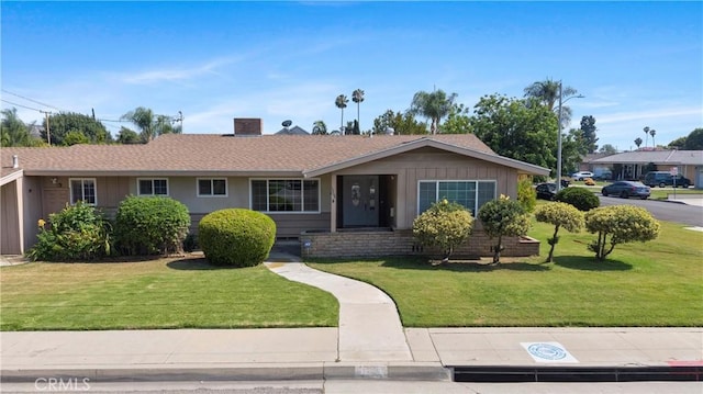 1206 E Vine Ave, West Covina, CA 91790 - ranch-style home with a front lawn, a chimney, and board and batten siding